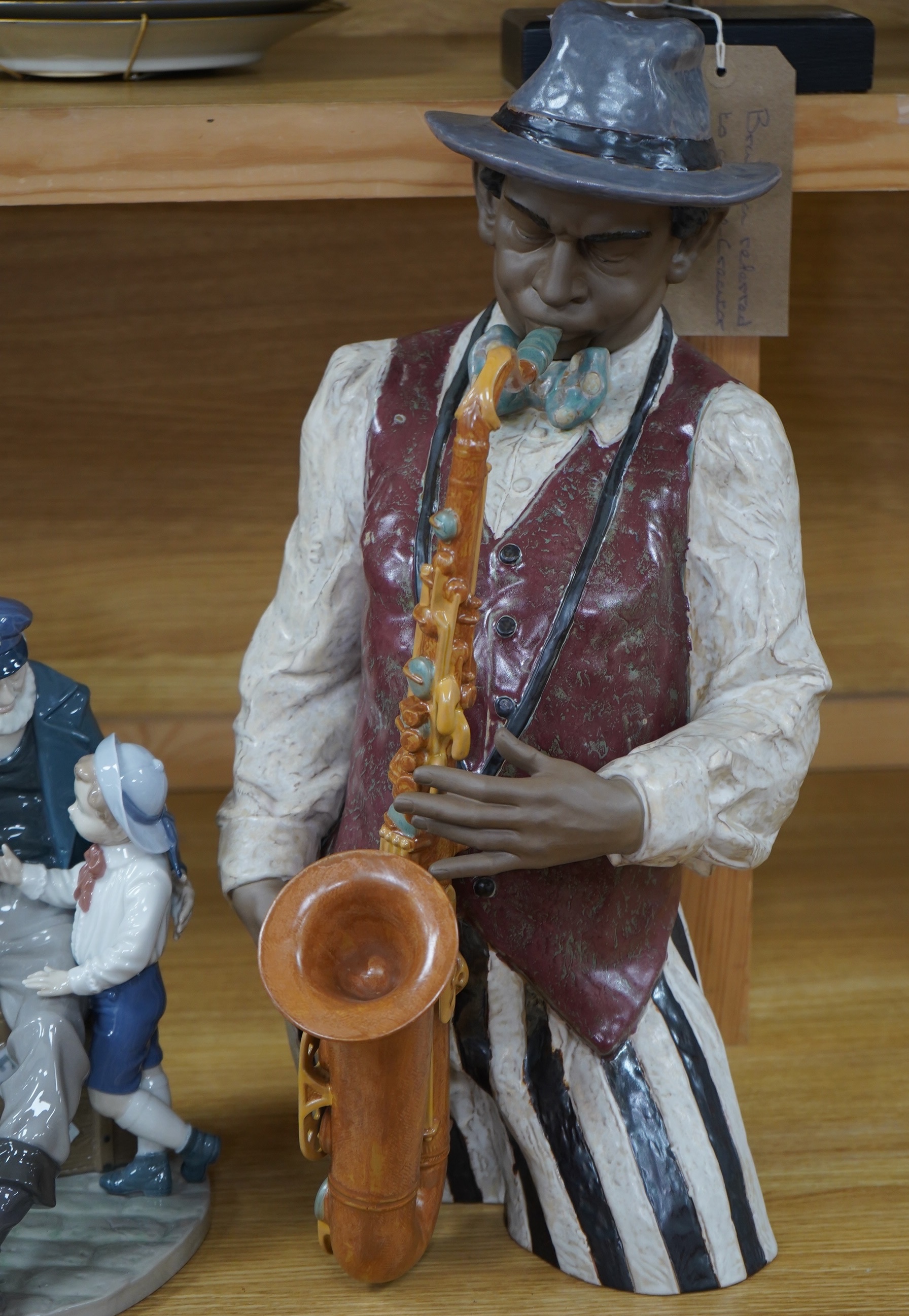 A Lladro figure ‘Playing the Blues’, 63cm high and a ‘Tall Yarn’ figure group of a fisherman and a boy. Condition - fisherman lacking the ship in his hand, otherwise good